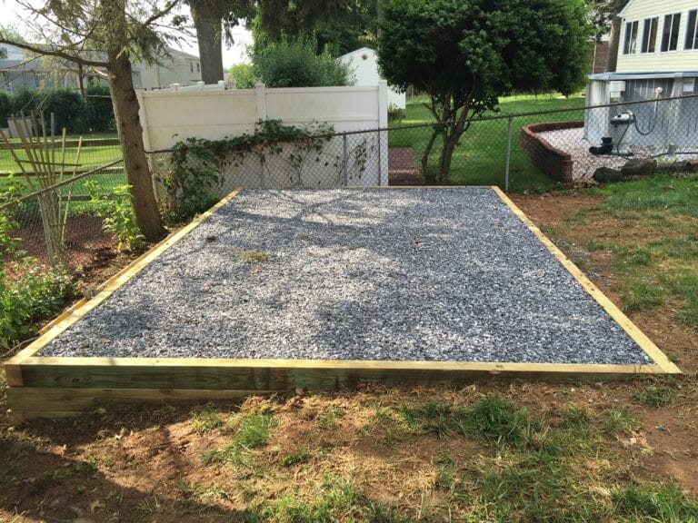 A gravel shed pad installation with a wood perimeter
