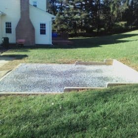 Gravel shed foundation installed in a sloped yard
