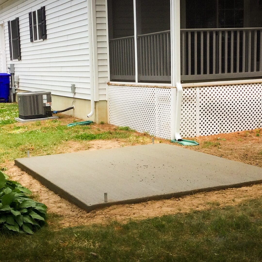 Shed footings with anchors on a floating concrete pad for a small shed