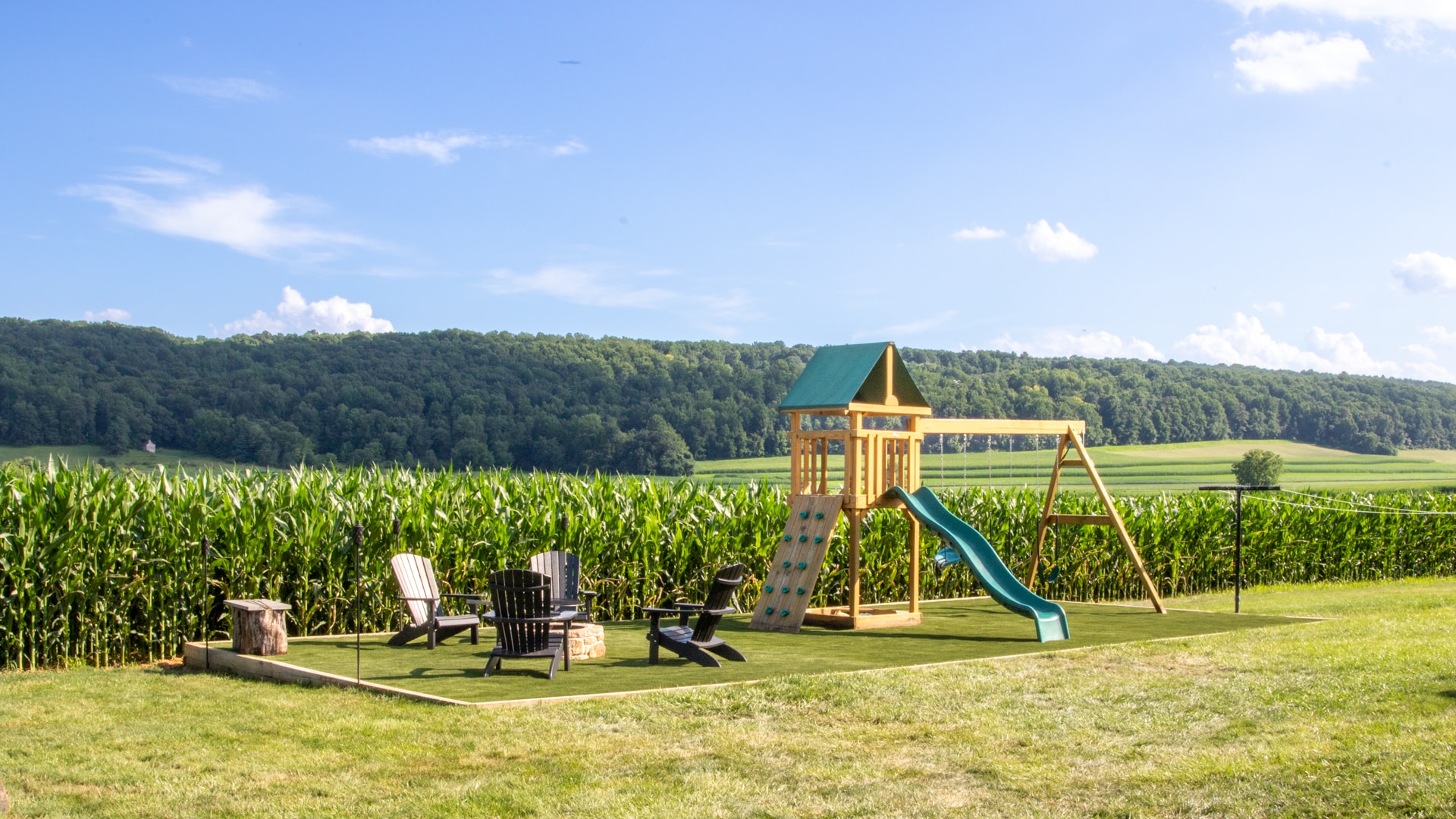photo of swingset and firepit on top of foundation after artificial grass installation