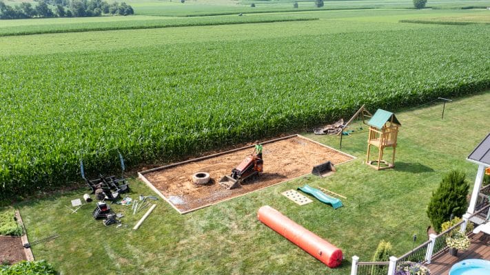 worker grading the site for turf installation
