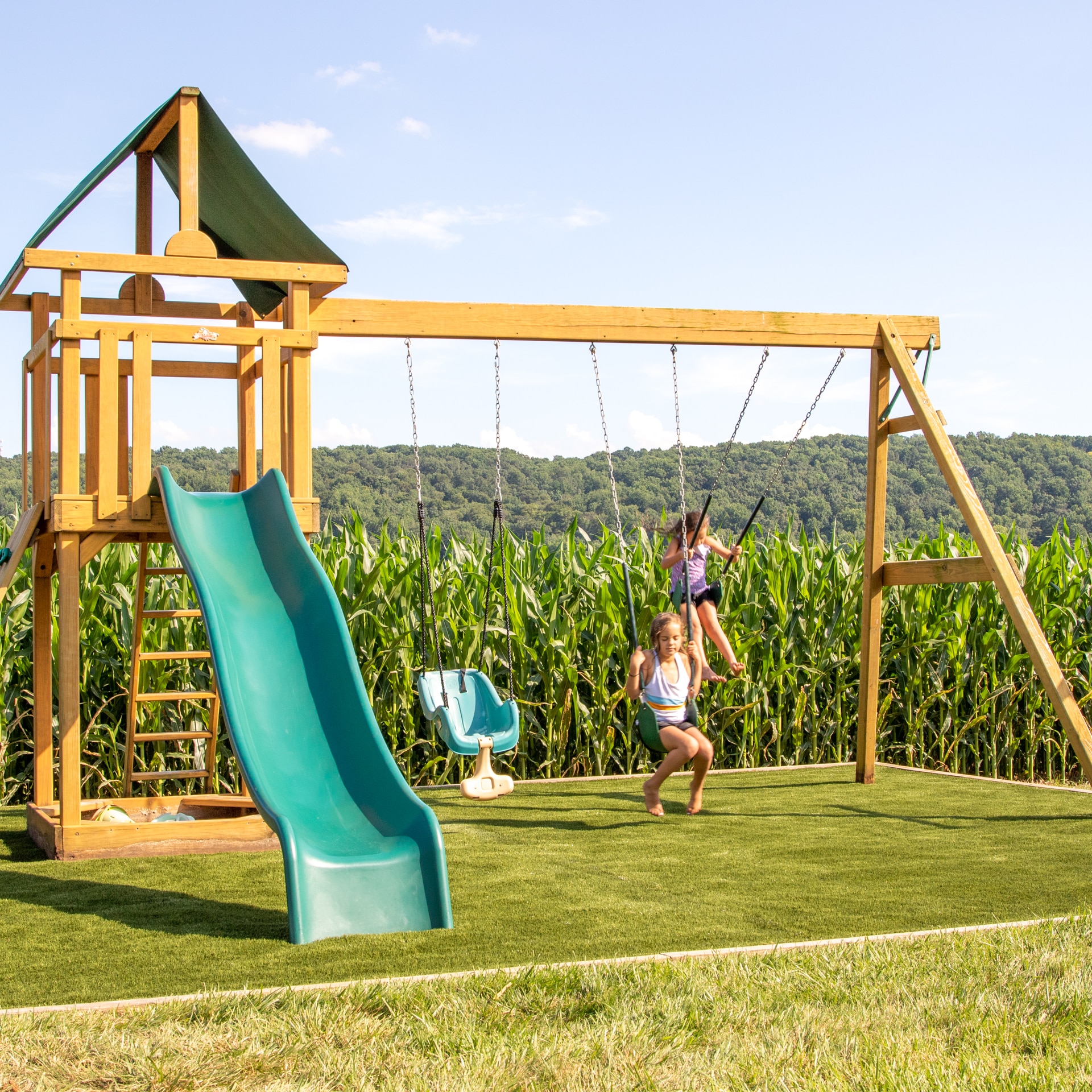 Gap, PA children swinging on swings on turf swingset base foundation